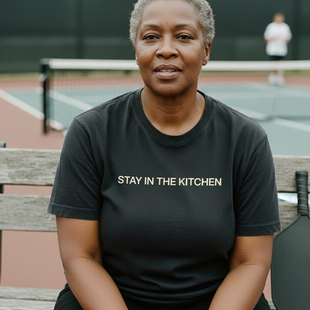 STAY IN THE KITCHEN — Cream on Pepper Pickleball Tee — worn on the court